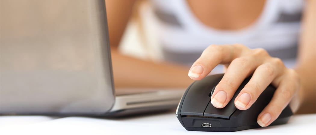 Close up van een draadloze muis met een vrouw en laptop op de achtergrond