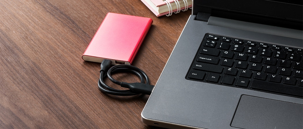 Een rode externe harde schijf aangesloten op een laptop