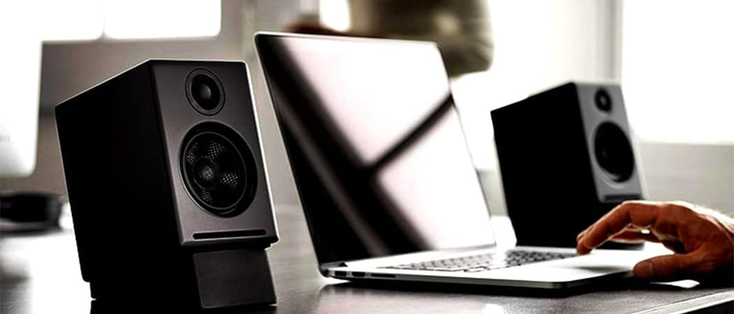 Een laptop tussen twee pc speakers.