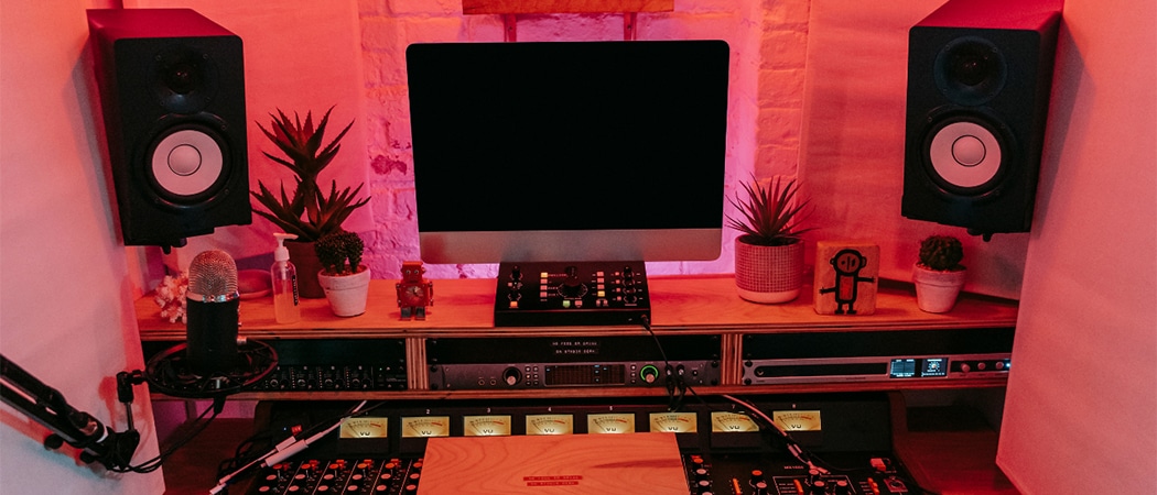 Een studio desk met een computer, controller en twee luidsprekers.