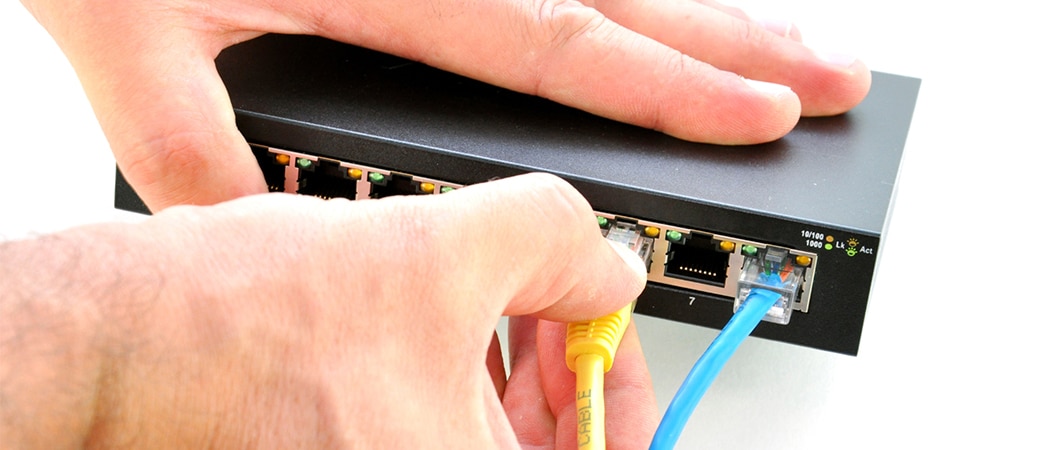 Een UTP-kabel die in een netwerk switch wordt gestoken.